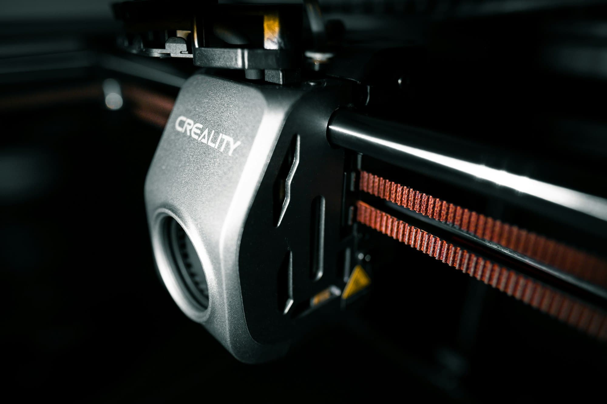 Close-up of a 3D printer print head on its gantry